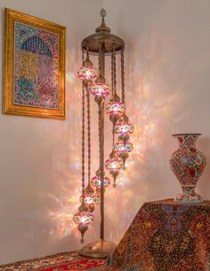 a lamp that is next to a table with a vase on it and lights in the background