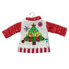 a red and white sweater with a christmas tree on the front, hanging from a hook