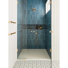 a blue tiled shower with brass fixtures and gold accents in a white walled bathroom area