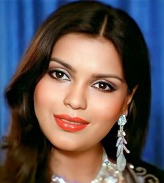 a close up of a woman with long dark hair and orange lipstick on her face