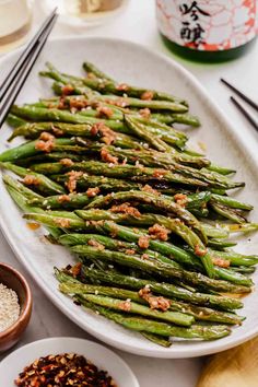 asparagus on a white plate with chopsticks next to it and rice