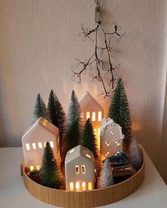 a wooden tray filled with miniature houses and trees