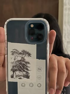 a person holding up an iphone case with drawings on it