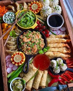 a tray filled with different types of food and dipping sauces on top of it