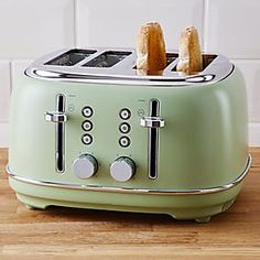 two pieces of toast sitting on top of a green toaster