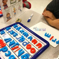 a child sitting at a table with letters and numbers on it