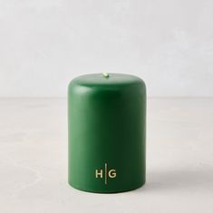 a green candle sitting on top of a white table