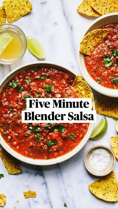 two bowls of salsa with tortilla chips and lime wedges on the side