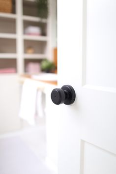 an open door with two black knobs on the front and side of it in a kitchen