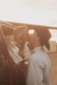 a man and woman kissing in the back of a car while standing next to each other