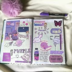 an open planner book with stickers on it and a purple pom - pom