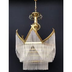 a chandelier hanging from the ceiling with glass beads and gold trimmings