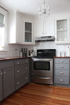 a kitchen with gray cabinets and white walls