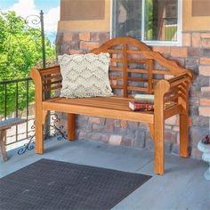 a wooden bench sitting on top of a patio next to a brick wall and door