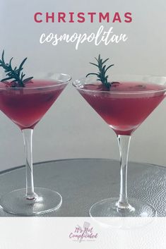 two martinis with rosemary garnish sit on a silver tray and text reads christmas cosmopolato