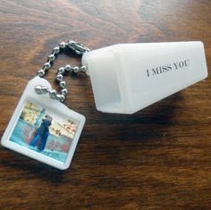 a keychain with a photo attached to it that says i miss you on the front