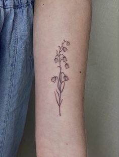 a small flower tattoo on the arm