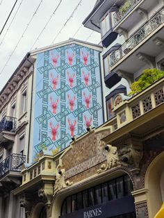 an ornate building with flowers painted on it's side and balconies above