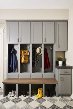 an entryway with gray cabinets and yellow rubber boots