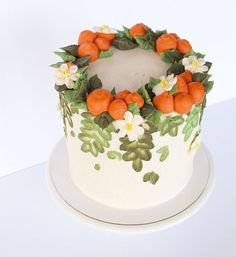 a cake decorated with oranges and white flowers