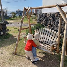 a teddy bear sitting on top of a wooden swing