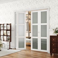 a bedroom with white walls and wood flooring, two mirrored closet doors open to reveal a walk - in closet