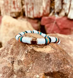 a couple of bracelets sitting on top of a rock