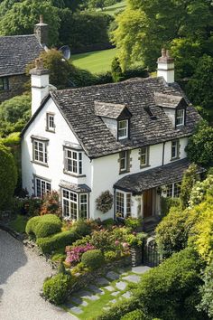 White manor with stone roof among colorful gardens. Explore the quirky charm, secret staircases, and unintentional labyrinths of British country houses, where historical oddities meet modern mishaps in the most delightful way.