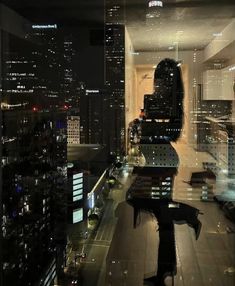 a city view from a high rise window at night with skyscrapers in the background