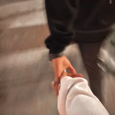 two people holding hands while walking down stairs