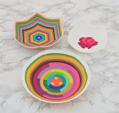 three bowls with different designs on them sitting on a marble counter top next to each other