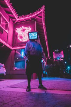 a man standing in front of a building with neon lights