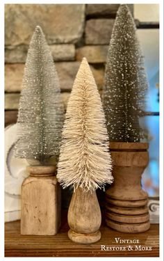 three small christmas trees sitting on top of a wooden table