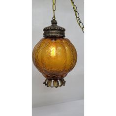 a yellow glass hanging light with chain around it