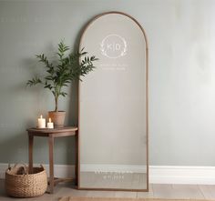 a large mirror next to a table with a potted plant on it and candles