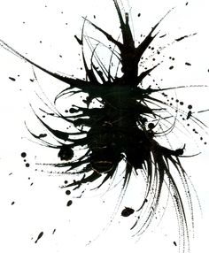 black ink splattered on white paper with an artistic design in the middle and bottom