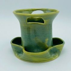 a green ceramic cup and saucer with handles