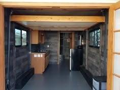 the inside of an rv with wood paneling and black appliances