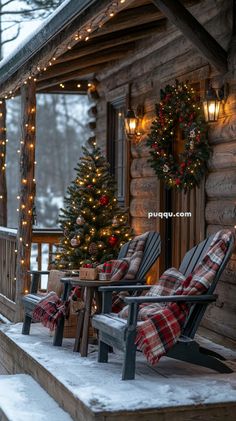 two wooden chairs sitting on top of a snow covered porch next to a christmas tree