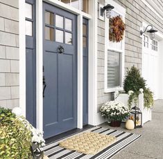 a blue front door on a gray house