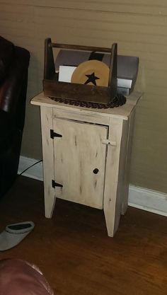 a small wooden table with a record player on it's top and a brown leather chair in the background