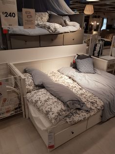 a bed with pillows and blankets on it in a room filled with other furniture items