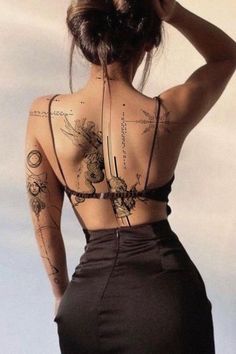 the back of a woman's body with tattoos on her upper and lower half