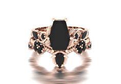 a ring with black stones and gold accents on it's sides, in front of a white background