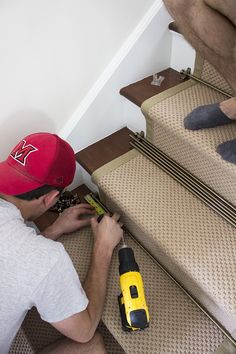 a man is working on some stairs with a screwdriver and drill bit in his hand