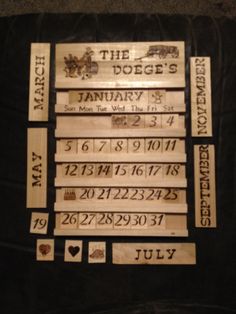 some wooden signs are hanging on a black cloth with numbers and dates in the middle