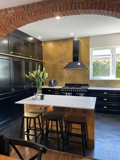 a kitchen with black cabinets and white counter tops, along with an island in the middle