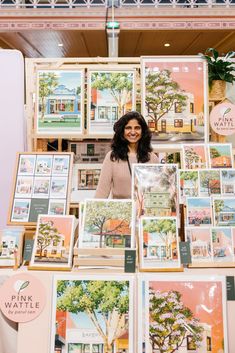 a woman standing in front of a table full of pictures and cards on it's sides