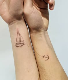 two people with matching tattoos on their arms, one has a sailboat and the other has an anchor