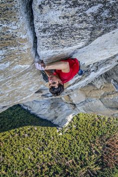 a man climbing up the side of a mountain with his hands on his hipss